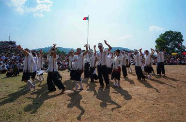  ကယန်း အမျိုးသားနေ့ အခမ်းအနားများ နေရာခွဲ ကျင်းပခဲ့ရ   သတင်းနှင့် မီဒီယာ ကွန်ရက်။ ၂၀၂၆ ခုနှစ်၊ ဧပြီလ ၁၁ ရက်။   ကရင်နီ (ကယား) ပြည် အတွင်းရှိ နယ်မြေလုံခြုံရေး အခြေအနေများကြောင့် (၂၆) ကြိမ်မြောက် ကယန်း အမျိုးသားနေ့ အခမ်းအနားကို ယခင်နှစ်များကဲ့သို့ စုပေါင်းကျင်းပနိုင်ခြင်းမရှိဘဲ ဒေသအသီးသီး၌ နေရာခွဲ၍ အကန့်အသတ်များဖြင့်သာ ကျင်းပခဲ့ကြရသည်။   ဧပြီလ ၁၀ ရက်နေ့တွင် ကျရောက်သည့် ကယန်းအမျိုးသားနေ့ကို ယခင်က ကယန်းဒေသအတွင်း သတ်မှတ် ထားသည့် စုရပ်တစ်ခုတည်း၌ ခမ်းနားစွာ ကျင်းပခဲ့ကြသော်လည်း၊ ယခုနှစ်တွင်မူ စစ်ရေးနှင့် လုံခြုံရေးစိုးရိမ် ချက်များကြောင့် ဒီးမော့ဆို၊ ဖယ်ခုံ၊ ဆီးဘူး၊ ပီကင်းနှင့် သံတောင် အစရှိသည့် နေရာ (၇) ခုထက်မနည်း ခွဲ၍ ကျင်းပခဲ့ရသည်။   ကယန်းအမျိုးသမီးအစည်းအရုံး (KYWO) ၏ တွဲဖက်အတွင်းရေးမှူး-၁ မူထရီဇာက “ပုံမှန်နှစ်တွေမှာ ဆိုလို့ရှိရင် နေရာ တစ်နေရာထဲကိုပဲ ကြီးကြီးမားမား လုပ်တယ်ပေါ့နော်။ ဒီနှစ်မှာတော့ ကရင်နီပြည် ကယန်းဒေသကို ကြည့်မယ် ဆိုလို့ရှိရင် ဒီးမော့ဆို အနောက်ခြမ်းမှာ၊ ဖယ်ခုံမြို့နယ်မှာ လုပ်တာရှိတယ်။ အလယ်ကယန်းဒေသ ဆီးဘူးမှာ လုပ်တာလည်း ရှိတယ်ပေါ့နော်။ ဆိုတော့ ဒီနှစ်ရဲ့ ထူးခြားချက်ကတော့ ကျမတို့ နေရာကို သုံးလေးခု လောက် ဖြန့်ကျက်ပြီးတော့ လုပ်လိုက်နိုင်တယ်” ဟု နေရာခွဲကျင်းပခဲ့ရသည့် အခြေအနေကို ပြောသည်။   လုံခြုံရေးအရ နေရာဖြန့်ကျက်ကျင်းပခဲ့ရသော်လည်း ဒေသခံလူထု၏ အမျိုးသားရေးစိတ်ဓာတ်ဖြင့် ပူးပေါင်း ပါဝင်မှုမှာ အားကောင်းခဲ့ပြီး၊ အခမ်းအနားသို့ မတက်ရောက်နိုင်သည့် စစ်ဘေးရှောင်များကလည်း မိမိတို့ စခန်း များ၌ပင် ကိုယ်ထူကိုယ်ထ အစီအစဉ်များဖြင့် ကျင်းပခဲ့ကြသည်။     မူထရီဇာကပင် ဆက်လက်၍ “ဘယ်လိုအခြေအနေ ဘယ်လို နေရာမျိုးမှာပဲ ရောက်ရောက် ကယန်းအမျိုးသား နေ့၊ ကယန်းနှစ်သစ်ကူး အခမ်းအနားတွေကို ကျင်းပနေဖို့လိုတယ်” ဟု ပြောသည်။   ကယန်းမျိုးဆက်သစ်လူငယ် (KNGY) ၏ ဒုဥက္ကဋ္ဌ မူမာရီယာကလည်း ယခုကဲ့သို့ အခြေအနေများကြားမှ အမျိုးသားနေ့ကို ဆက်လက်ကျင်းပရခြင်းသည် လူမျိုးတစ်မျိုး၏ ဝိသေသလက္ခဏာ (Identity) ကို ထိန်းသိမ်းရန်ဖြစ်ကြောင်း ဆိုသည်။   မူမာရီက “အဓိက ရည်ရွယ်ချက်က အမျိုးသားအမှတ်အသား (Identity) ကို တည်တံ့စေရန် ဘာသာစကား၊ ယဉ်ကျေးမှု၊ စာပေ ထိန်းသိမ်းရန် ကယန်းလူမျိုးအတွင်း ညီညွတ်မှု တည်ဆောက်ရန် ဖြစ်တယ်” ဟု ပြော သည်။   ထို့အပြင် မျိုးဆက်သစ်လူငယ်များအနေဖြင့် ရှေးယခင်က ရှိခဲ့သည့် မညီညွတ်မှု အယူအဆအစွဲများကို ဘေးဖယ်ကာ ညီညွတ်မှု မှတ်တိုင်သစ် တည်ဆောက်ကြရန်လည်း KNGY က တိုက်တွန်းထားသည်။   “လူငယ်တွေ အနေနဲ့ မညီညွတ်မှု အမွေအနှစ်ကို ဆက်မယူသွားဖို့လိုတယ်။ သမိုင်းတစ်လျောက် မရှိခဲ့ဖူးသော ညီညွတ်မှုကို ဒီမျိုးနွယ်စုလူငယ်အင်အားဖြင့် အတွေးအခေါ်အသစ်နဲ့ ညီညွတ်မှုအတွက် သမိုင်းမှတ်တိုင် တည် ဆောက်သွားဖို့ လိုအပ်ကြောင်း တိုက်တွန်းလိုပါတယ်” ဟု မူမာရီယာက ပြောသည်။   ကယန်းအမျိုးသားနေ့ကို ကျင်းပရခြင်းသည် ကယန်းလူမျိုးတို့၏ စာပေ၊ ဘာသာစကားနှင့် ယဉ်ကျေးမှု အမွေ အနှစ်များ မပျောက်ပျက်အောင် ထိန်းသိမ်းစောင့်ရှောက်ရန်ဖြစ်ကြောင်း ကယန်းမျိုးဆက်သစ်လူငယ် (KNGY) ဒုဥက္ကဋ္ဌ မူမာရီယာက ဆိုသည်။     ၎င်းက ကယန်းခေါင်းဆောင်များသည် ကယန်းဝိသေသလက္ခဏာများ ထိန်းသိမ်းနိုင်ရေးအတွက် ၂၀၀၀ ပြည့်နှစ် တွင် ကျင်းပသည့် ပထမအကြိမ် ကယန်းအမျိုးသားညီလာခံ၌ ဧပြီ ၁၀ ရက်နေ့ကို အမျိုးသားနေ့အဖြစ် စတင် သတ်မှတ်ခဲ့ကြခြင်းဖြစ်ပြီး ယခုနှစ်တွင် (၂၆) ကြိမ်မြောက်အထိ ရောက်ရှိလာခြင်းဖြစ်ကြောင်း ရှင်းပြသည်။   ယခုနှစ် ကယန်းအမျိုးသားနေ့ကို ပြည်တွင်း၌သာမက ဂျပန်၊ ကိုးရီးယား၊ ထိုင်းနှင့် စင်္ကာပူနိုင်ငံရောက် ကယန်း လူမျိုးများကလည်း သက်ဆိုင်ရာ နိုင်ငံအလိုက် အခမ်းအနားများကို ကျင်းပခဲ့ကြသည်။   #ကယန်းအမျိုးသားနေ့  