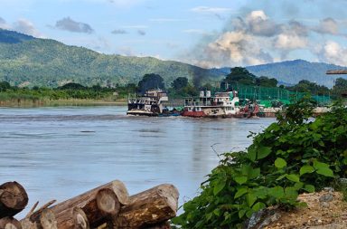 ရွှေကူတွင် စစ်အုပ်စု စစ်သင်္ဘောတစ်စီး မီးလောင်၊ လေကြောင်းမှ ကလပ်စတာဗုံးဖြင့် လက်တုံ့ပြန် သတင်းနှင့် မီဒီယာ ကွန်ရက်။ ၂၀၂၆ ခုနှစ်၊ ဩဂုတ်လ ၂၉ ရက် မန္တလေးမှ ဆန်တက်လာသည့် စစ်အုပ်စု၏ စစ်သင်္ဘောများ ကမ်းကပ်ထားသည့် ကချင်ပြည်၊ ရွှေကူမြို့နယ်တွင် တော်လှန်ရေး အင်အားစုများ၏ ဒရုန်းဖြင့် တိုက်ခိုက်မှုကြောင့် စစ်သင်္ဘောတစ်စီး မီးလောင် ပျက်စီးခဲ့ပြီးနောက် စစ်တပ်က ကလပ်စတာ (Cluster) ဗုံးများ အသုံးပြု၍ လေကြောင်းမှ လက်တုံ့ပြန် ဗုံးကြဲတိုက်ခိုက်လျက်ရှိ သည်။ မန္တလေးမြို့မှ ဩဂုတ်လ ၂၁ ရက်တွင် ထွက်ခွာလာသည့် အင်အား ရာနှင့်ချီ ပါဝင်သော စစ်တပ်၏ စစ်သင်္ဘော ရေယာဉ် ၁၄ စီးသည် ဩဂုတ်လ ၂၈ ရက်နေ့ နံနက်ပိုင်းတွင် ရွှေကူမြို့၊ အမှတ် (၃) ဆိပ်ကမ်း သို့ ရောက်ရှိ ကမ်းကပ်ခဲ့ခြင်း ဖြစ်သည်။ အဆိုပါ သင်္ဘောများ ကမ်းကပ်ထားစဉ် ဩဂုတ်လ ၂၈ ရက် ည ၁၁ နာရီခန့်တွင် ကချင်လွတ်လပ်ရေးတပ်မတော် (KIA) နှင့် ပြည်သူ့ကာကွယ်ရေးတပ်မတော် (PDF) ပူးပေါင်းအဖွဲ့များက ကာကွယ်ရေး ဒရုန်းများဖြင့် ဝင်ရောက် တိုက်ခိုက်ခဲ့ခြင်းဖြစ်သည်။ အဆိုပါ တိုက်ခိုက်မှုကြောင့် စစ်သင်္ဘောတစ်စီး မီးလောင် ပျက်စီးခဲ့သည့်အပြင် စစ်တပ်ဘက်မှ စစ်သား တစ်ဦး၊ ရဲတပ်သားတစ်ဦးနှင့် ကုန်တင်စိစစ်ပေးနေသူတစ်ဦး သေဆုံးကာ ၁၄ ဦးထက်မနည်း အပြင်းအထန် ဒဏ်ရာရရှိခဲ့ကြောင်း ဒေသခံ မြေပြင် သတင်းရင်းမြစ်များက ပြောသည်။ ဒေသခံ တော်လှန်ရေး သတင်းရင်းမြစ်တစ်ဦးက “စစ်အုပ်စု စစ်သင်္ဘောတွေ ရွှေကူ အမှတ် (၃) ဆိပ်ကမ်းမှာ ဆိုက်ထားချိန် ဒရုန်းနဲ့ ဝင်ပစ်တာ။ သင်္ဘောတစ်စီး လုံးဝ မီးလောင်သွားတယ်။ သူတို့ဘက်က အထိနာသွားတော့ မြစ်ကမ်းဘေးရွာတွေကို လက်နက်ကြီးတွေနဲ့ ရမ်းသမ်းပစ်သလို လေကြောင်းကနေလည်း ချက်ချင်း လက်တုံ့ ပြန် ဗုံးကြဲတာတွေ လုပ်လာတာ” ဟု ပြောသည်။ သင်္ဘောများ တိုက်ခိုက်ခံရအပြီး ဩဂုတ်လ ၂၈ ရက် ညပိုင်းတွင်ပင် စစ်အုပ်စုတပ်သည် မံစီမြို့နယ်၊ ဟန်ထက် ကျေးရွာရှိ စစ်ဘေးရှောင် စခန်းအနီးသို့ ဂျက်တိုက်လေယာဉ် နှစ်စင်းဖြင့် နိုင်ငံတကာက သုံးစွဲခွင့် ပိတ်ပင်ထား သည့် ကလပ်စတာဗုံး ၄ လုံး ကြဲချခဲ့ရာ ကျေးလက်ကျန်းမာရေး ဆေးခန်းနှင့် မော်တော်ယာဉ် တစ်စီး ပျက်စီးခဲ့ပြီး အရပ်သားတစ်ဦး ဗုံးစထိမှန် ဒဏ်ရာရရှိခဲ့သည်။ တော်လှန်ရေး တပ်ဖွဲ့နှင့် နီးစပ်သူ တစ်ဦးက “စစ်တပ်က ရွှေကူမှာ အထိနာသွားတော့ ဒီဘက် မံစီကို မဲပြီး ဂျက် ဖိုက်တာနှစ်စီးနဲ့ ဗုံးလာကြဲတာ။ ည ၁၁ နာရီလောက်မှာ ဂျက်ဖိုက်တာနှစ်စီး ရှေ့ဆင့်နောက်ဆင့် ရောက် လာပြီး တိုက်နယ်ဆေးရုံကို ဗုံးကြဲသွားတာ” ဟု ပြောသည်။ ထို့ပြင် ဩဂုတ်လ ၂၉ ရက်နေ့တွင်လည်း ရွှေကူမြို့ ဆိပ်ကမ်း၌ ပစ္စည်းများ သယ်ယူချကင်းနေစဉ် ဗုံးကျ ရောက် ပေါက်ကွဲမှုများ ထပ်မံဖြစ်ပွားခဲ့သလို စစ်အုပ်စုတပ်က ဂျက်လေယာဉ်များဖြင့် ဆင့်ပွား ပေါက်ကွဲစေတတ်သည့် ကလပ်စတာဗုံးများကို ဆက်လက် ကြဲချနေကြောင်း ဆိုသည်။ လက်ရှိတွင် စစ်အုပ်စုတပ်သည် ရွှေကူမြို့ပေါ်ရှိ အရပ်သား အိမ်စီးကားများနှင့် ကားဂိတ်အချို့မှ မော်တော် ယာဉ်များကို ချောဆွဲကာ သင်္ဘောပေါ်ပါလာသည့် စစ်လက်နက် ပစ္စည်းများနှင့် စစ်အင်အားများကို ရွှေကူအခြေ စိုက် တပ်ရင်းများအတွင်းသို့ ပို့ဆောင်နေပြီး စင်းခန်းနှင့် ဗန်းမော်ဘက်သို့ ဆက်လက် စစ်ကြောင်းထိုးနိုင်ရန် အင်အားဖြည့်တင်းလျက်ရှိသည်။ စစ်သင်္ဘောများ ရွှေကူမှတစ်ဆင့် ဗန်းမော်ဘက်သို့ ဆက်လက် ဆန်တက်မည်ဖြစ်ရာ မြစ်ကြောင်းတစ်လျှောက် လေကြောင်းတိုက်ခိုက်မှုများနှင့် စစ်ကြောင်းထိုးမှုများ ပိုမို ပြင်းထန်လာနိုင်သဖြင့် စင်းခန်း၊ ဗန်းမော်နှင့် ဧရာဝတီမြစ်ကမ်းဘေး ကျေးရွာများမှ ဒေသခံ ပြည်သူများအနေဖြင့် ဘေးလွတ်ရာသို့ စနစ်တကျ တိမ်းရှောင် ကြရန် တော်လှန်ရေး အင်အားစုများက သတိပေး နှိုးဆော်ထားသည်။ ဓာတ်ပုံ - (Banmaw Scout Team / ဧရာဝတီမြစ်ကြောင်းအတိုင်း ဆန်တက်လာသည့် စစ်အုပ်စုတပ်၏ စစ်သင်္ဘောများအား တွေ့ရစဉ်။) #ရွှေကူတိုက်ပွဲ