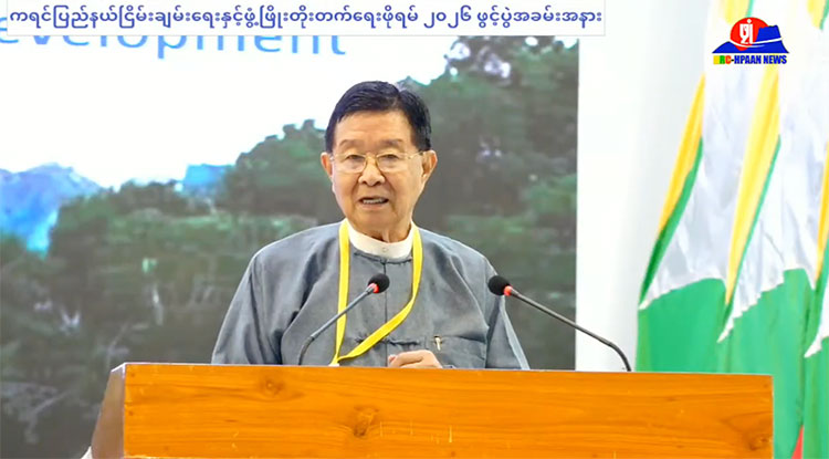 'ဝ' ထက် ကရင်က အခွင့်အရေး ပိုရထားဟု စစ်အုပ်စု ငြိမ်းချမ်းရေး အကြံပေး ဦးအောင်မင်း ပြော သတင်းနှင့် မီဒီယာ ကွန်ရက်။ ၂၀၂၆ ခုနှစ်၊ အောက်တိုဘာလ ၉ ရက်။ ကရင်တိုင်းရင်းသားများသည် ကရင်ပြည်နယ် ရရှိထားပြီးသား ဖြစ်သဖြင့် ပြည်နယ် မရရှိသေးသည့် “ဝ” တိုင်းရင်းသားများထက် ပိုမိုအဆင့်မြင့်သည့် အခွင့်အရေးကို ရရှိထားသည်ဟု အမျိုးသား စည်းလုံးညီညွတ် ရေးနှင့် ငြိမ်းချမ်းရေး ဖော်ဆောင်မှု ညှိနှိုင်းရေး ကော်မတီ (NSPNC) အကြံပေးအဖွဲ့ ခေါင်းဆောင် ဦးအောင်မင်း က ပြောဆိုလိုက်သည်။ ကရင်ပြည်နယ်၌ ပြုလုပ်ခဲ့သည့် ကရင်ပြည်နယ် ငြိမ်းချမ်းရေးနှင့် ဖွံ့ဖြိုးတိုးတက်ရေး ဖိုရမ် အဖွင့်မိန့်ခွန်းတွင် ဦးအောင်မင်းက ထိုသို့ ထည့်သွင်း ပြောဆိုခဲ့ခြင်းဖြစ်သည်။ ဦးအောင်မင်းက “ဖက်ဒရယ်မှာ အဓိက အချက် ၂ ချက်ပဲ။ အဲဒါ ဘာလဲဆိုရင် Share Rule နဲ့ Self Rule။ Self Rule ဆိုတာက ဥပဒေကို ကိုယ့်ဘာသာကိုယ် ထုတ်တယ်။ Share Rule ဆိုတာကတော့ ရတဲ့ သယံဇာတ အကျိုးခံစားခွင့်ကို ခွဲဝေပြီး မျှတ ခံစားမယ်ပဲ ဖြစ်တယ်။ အဲတော့ ခင်ဗျားတို့ ဒီ Self Rule ကို ပြောလို့ရှိရင် ခင်ဗျားတို့ ကရင်ပြည်နယ်ဟာ ကရင်ပြည်နယ်ဆိုတဲ့ အခွင့်အရေး ရပြီးသားဖြစ်တယ်။ အဲတော့ ဒါကို နှိုင်းယှဉ် ပြီး ပြောမယ်ဆိုရင် ‘ဝ’ တို့ ဘာတို့က ‘ဝ’ ပြည်နယ် တောင်းတယ်။ အဲတော့ ‘ဝ’ ကို ပြည်နယ် ပေးလို့ မရသေး ဘူး။ ခင်ဗျားတို့က ကရင်ပြည်နယ် ရပြီးသားဖြစ်တဲ့အတွက် ခင်ဗျားတို့က အဆင့်မြင့်ပြီးသား ဖြစ်တယ်” ဟု ပြောသည်။ သို့သော် UWSP/UWSA ဦးဆောင်သည့် “ဝ” တိုင်းရင်းသားများမှာ ပြည်နယ်အဆင့် တရားဝင် မရရှိသေးသော် လည်း ဗဟိုအစိုးရ၏ ထိန်းချုပ်မှုအောက်တွင် မဟုတ်ဘဲ ကိုယ်ပိုင်အုပ်ချုပ်ရေး၊ ကိုယ်ပိုင်ဥပဒေ၊ ကိုယ်ပိုင်တရား စီရင်ရေး စသည့် ကိုယ်ပိုင်ပြဋ္ဌာန်းခွင့်များကို နှစ်ပေါင်း ၄၀ နီးပါး အပြည့်အဝ ဖော်ဆောင်ထားနိုင်သည့် အဖွဲ့အစည်း ဖြစ်သည်။ ကရင်တိုင်းရင်းသားများမှာမူ ကရင်ပြည်နယ် ရရှိထားသော်လည်း ဗဟိုအစိုးရ၏ ဝင်ရောက်စွက်ဖက်ထိန်းချုပ်မှု အောက်တွင်သာ ရှိနေသေးသည်။ အဆိုပါ ပြည်နယ်အဆင့်နှင့် ကိုယ်ပိုင်အုပ်ချုပ်ရေး တောင်းဆိုချက်များကို စစ်အုပ်စုဘက်က ၂၀၀၈ ဖွဲ့စည်းပုံ အခြေခံဥပဒေနှင့် NCA လမ်းကြောင်းမှတစ်ဆင့်သာ ဆွေးနွေးဆောင်ရွက်ရမည်ဟု ထိန်းချုပ်ထားသည်။ စစ်အုပ်စုသည် ၂၀၀၈ ဖွဲ့စည်းပုံ အခြေခံဥပဒေနှင့် NCA လမ်းကြောင်းမှတစ်ဆင့် ဒီမိုကရေစီနှင့် ဖက်ဒရယ် ပြည်ထောင်စု တည်ဆောက်မည်ဟု ပြောဆိုကာ တိုင်းရင်းသား လက်နက်ကိုင် အဖွဲ့အစည်းများနှင့် တွေ့ဆုံဆွေးနွေးမှုများ ပြုလုပ်နေသည်။ စစ်အုပ်စု၏ ပြည်ထောင်စု အတိုင်ပင်ခံကောင်စီ အဖွဲ့ဝင် မန်းငြိမ်းမောင်က “တိုင်းရင်းသားတွေရဲ့ အဆိုပြုချက် အပေါ်မှာမှ အစိုးရနဲ့ တပ်မတော်က ဒါကို ညှိနှိုင်းပြီးတော့မှ ဆောင်ရွက်ခဲ့တာပဲ ရှိတယ်။ တနည်းအားဖြင့် ပြော ရင် NCA ဆိုတာ တစ်ပြည်လုံး အပစ်အခတ် ရပ်စဲရေးဆိုတာ ကျနော်တို့ တိုင်းရင်းသားတွေ ဖော်တဲ့ဆေးပဲ။ အဓိက ဖော်တဲ့ဆေးနဲ့ ဆေးညွှန်းတွေက ကျနော်တို့ တိုင်းရင်းသားတွေက ဖော်ခဲ့တဲ့ဆေး။ အခုကျမှ ကိုယ်ဖော် တဲ့ဆေးကို ကိုယ်မစားရဲဘူး ဆိုတော့ ခင်ဗျားတို့ စဉ်းစားကြည့်၊ ဒါကို ကျနော် ပြောချင်တာ” ဟု ပြောသည်။ ထို့ပြင် NSPNC အကြံပေးအဖွဲ့ ခေါင်းဆောင် ဦးအောင်မင်းကလည်း NCA စာချုပ်တွင် ဖက်ဒရယ်စနစ် ပါရှိပြီး ဖြစ်၍ မဖျက်ဆီးသင့်ကြောင်း ဆက်လက် ပြောဆိုသည်။ ၎င်းက “NCA ထဲမှာ ဖက်ဒရယ်စနစ်ကို အခြေခံတဲ့ ပြည်ထောင်စုကြီးကို တည်ဆောက်မယ်ဆိုတာ ပါတယ်။ ဖွဲ့စည်းပုံ အခြေခံဥပဒေထဲမှာ အဲဒီကိစ္စ မပါဘူး။ ဖွဲ့စည်းပုံ အခြေခံဥပဒေထဲမှာ ဘာပါသလဲဆိုရင် ပါတီစုံ ဒီမိုက ရေစီစနစ်ကို ကျင့်သုံးမယ်ဆိုတာပဲ ပါတယ်။ ကျနော်တို့ NCA က ဖက်ဒရယ်စနစ်ကို ကျင့်သုံးတဲ့ အခြေခံ ပြည် ထောင်စုကြီး တည်ဆောက်မယ်ဆိုတဲ့အတွက် ကျနော်တို့ထဲမှာ တိုင်းရင်းသားတွေကို ပေးထားတဲ့ အခွင့်အရေး က ပိုပြီးတော့ များတယ်။ အဲတော့ NCA ကို မဖျက်သင့်ဘူး။ ဖက်ဒရယ်ကို ရအောင် လုပ်ထားပြီးသား ဖြစ်တာ ကို ဘာလို့ ဖျက်မှာလဲ” ဟု ပြောသည်။ သို့သော်လည်း ၂၀၂၁ ခုနှစ် စစ်တပ်က အာဏာသိမ်းပြီးနောက်ပိုင်း NCA စာချုပ်မှာ ပျက်ပြယ်သွားပြီဖြစ်ကြောင်း တိုင်းရင်းသား လက်နက်ကိုင် အဖွဲ့အစည်းများက တုံ့ပြန်ထားကြသည်။ တစ်ဖက်တွင် စစ်အုပ်စုက ငြိမ်းချမ်းရေး ဆွေးနွေးရန် ဖိတ်ခေါ်နေသော်လည်း အခြားတစ်ဖက်တွင် ကရင်ပြည် နယ် အပါအဝင် တိုင်းရင်းသား ဒေသများသို့ စစ်ကြောင်းထိုးခြင်း၊ လေကြောင်းနှင့် ဒရုန်းများဖြင့် ဗုံးကြဲခြင်း၊ နေအိမ်များကို မီးရှို့ဖျက်ဆီးခြင်းနှင့် ဒေသခံများကို ဖမ်းဆီးနှိပ်စက်ခြင်း စသည့် လူ့အခွင့်အရေး ချိုးဖောက်မှု များကို ဆက်တိုက် ကျူးလွန်လျက်ရှိသည်။ #NCA #NSPNC #Karenpeaceforum #Uaungmin #myanmarpeaceprocess