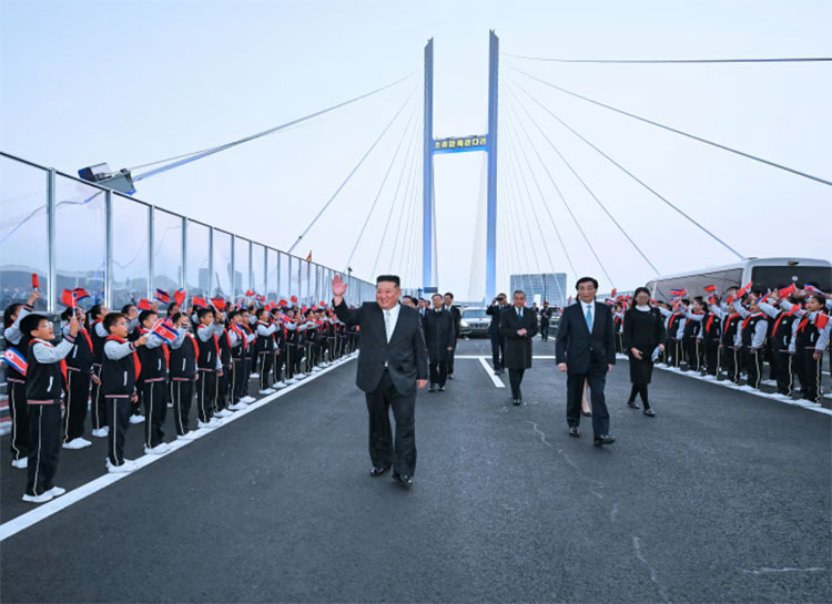 မြောက်ကိုရီးယားခေါင်းဆောင် ကင်ဂျုံအွန် နယ်စပ်တံတားသစ်မှတစ်ဆင့် တရုတ်နိုင်ငံသို့ သွားရောက် သတင်းနှင့် မီဒီယာ ကွန်ရက်။ ၂၀၂၆ ခုနှစ်၊ အောက်တိုဘာလ ၂၆ ရက်။ မြောက်ကိုရီးယား ခေါင်းဆောင် ကင်ဂျုံအွန်သည် နှစ်နိုင်ငံ စီးပွားရေးနှင့် ကုန်သွယ်ရေး ပူးပေါင်းဆောင်ရွက်မှု မြှင့်တင်ရန်အတွက် မကြာသေးမီက ဖွင့်လှစ်ခဲ့သည့် မင်းယားမြစ် (New Yalu River) တံတားသစ်မှတစ်ဆင့် တရုတ်နိုင်ငံ ဒန်တုန်းမြို့သို့ သွားရောက်ခဲ့သည်။ အောက်တိုဘာ ၂၄ ရက် ခရီးစဉ်အတွင်း တရုတ် အဆင့် ၄ ခေါင်းဆောင် ဝမ်ဟူနင်းက အနီးကပ် လိုက်ပါဆောင်ရွက်ခဲ့ပြီး သမ္မတ ရှီကျင့်ဖိန်၏ နှုတ်ခွန်းဆက်စကားကို ပေးအပ်ခဲ့သည်။ အရှည် ၃ ကီလိုမီတာရှိ တံတားသစ်သည် မြောက်ကိုရီးယားအတွက် လိုအပ်သည့် စက်ကိရိယာ၊ ကုန်ကြမ်းနှင့် စွမ်းအင် ပို့ဆောင်ရေး အခက်အခဲများကို ပြေလည်စေမည်ဖြစ်သည်။ ခရီးစဉ်အတွင်း ကင်ဂျုံအွန်သည် ဒန်တုန်းမြို့ရှိ မော်တော်ယာဉ်စက်ရုံသို့ သွားရောက်ကြည့်ရှုခဲ့ပြီး ၁၉၅၀-၅၃ ကိုရီးယားစစ်ပွဲအတွင်း ကျဆုံးခဲ့သည့် တရုတ်စစ်သည်များ၏ အထိမ်းအမှတ်ကျောက်တိုင်တွင် ဂါရဝပြုခဲ့သည်။